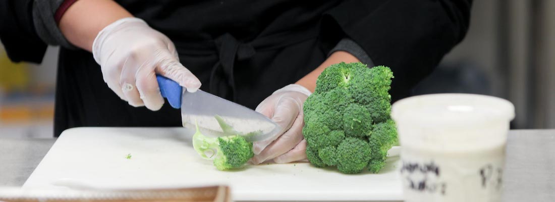 Student cutting broccoli